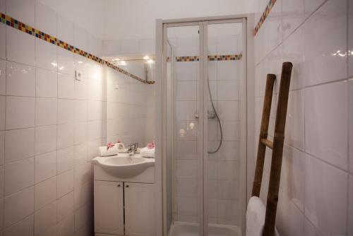a white bathroom with a shower and a sink at Villa Kalliste in Porto Ota