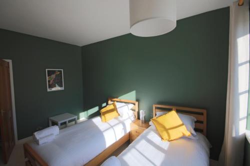 two beds in a room with green walls at Mid-mile in Edinburgh