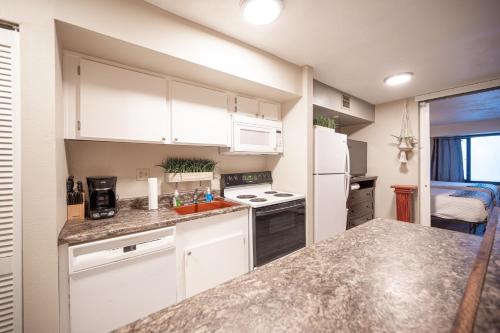 a kitchen with white cabinets and a counter top at Stay Together Suites - Suite On The Strip Steps From Bellagio & Cosmo Sleeps 11 - NO RESORT FEE in Las Vegas