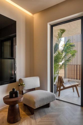 a living room with a chair and a television at The Newel Psychiko in Athens