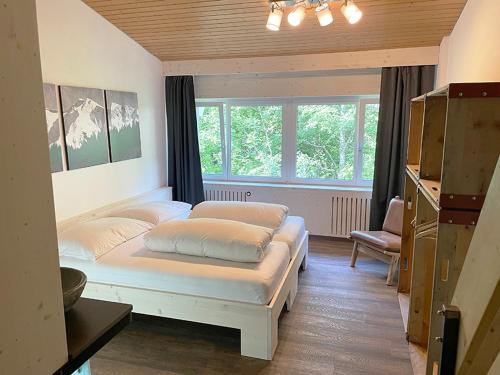 1 dormitorio con 2 camas y ventana en Hotel Go-In en Sörenberg