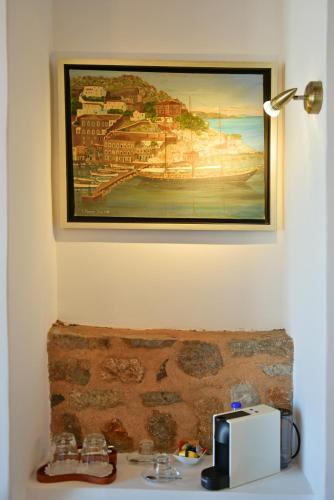 a picture hanging on a wall above a sink at Hotel Sophia in Hydra
