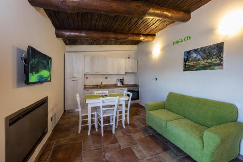 sala de estar con sofá verde y mesa en Residence Pietrabianca, en Casal Velino