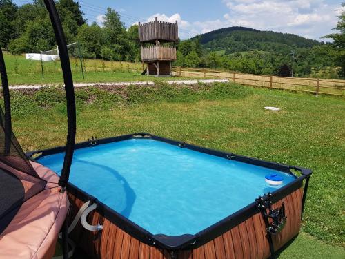 a hot tub in a hammock in a field at Chata Hrozenka WELLNESS in Nový Hrozenkov