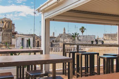 a patio with tables and stools and a view of the city at Sui Tetti Luxury Rooms in Lecce