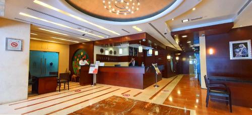 a lobby of a restaurant with a counter and chairs at Tulip Hotel Apartments in Dubai