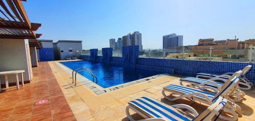 a balcony with chairs and a swimming pool on a building at Tulip Hotel Apartments in Dubai