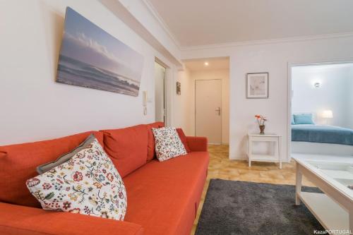 a living room with a red couch and a bed at Santa Catarina Terrace in Estoril