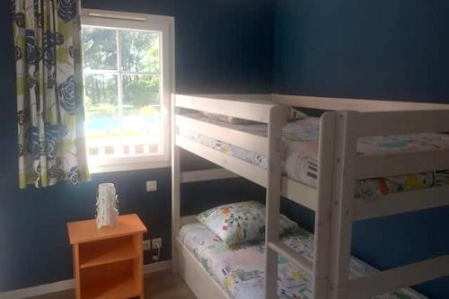 une chambre avec deux lits superposés et une fenêtre dans l'établissement Maison confortable à Lacanau avec piscine partagée, à Lacanau