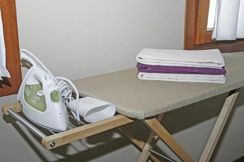a table with a iron and a stack of towels at Particolari del Brenta in Oriago Di Mira