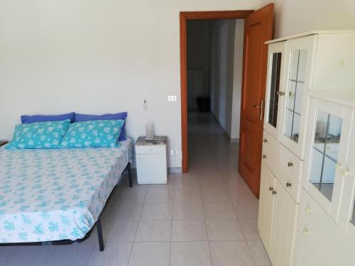 1 dormitorio con 1 cama y puerta que da a un pasillo en Appartamento da Anna, en Falcone