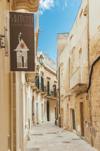 an alley with a sign on the side of a building at Sui Tetti Luxury Rooms in Lecce