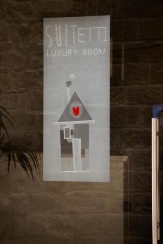 a sign in a window with a house with a heart on it at Sui Tetti Luxury Rooms in Lecce