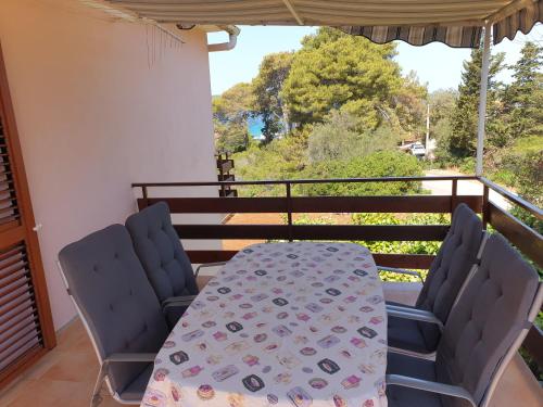 a table and chairs on a balcony with a view at Apartments Vidakovic in Ugljan