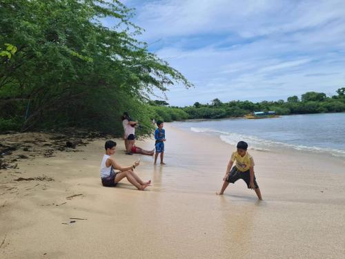 a group of children playing on the beach at Calatagan's Bahay Kubo - with Beach Access in Batangas City