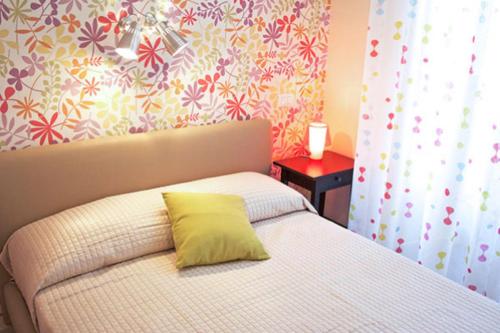 um quarto com uma cama com uma almofada amarela em In City-In em Catânia