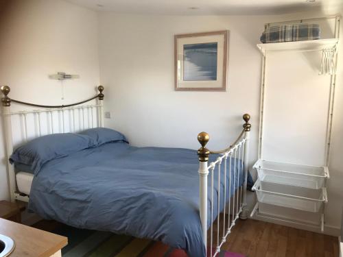 una camera da letto con un letto con lenzuola blu sopra di Flat Rocks, with parking, 100m from beach a Perranporth