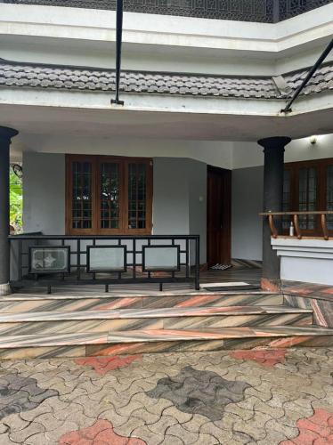 a patio with two benches on a building at H Villa in Nilambūr