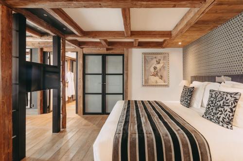 1 dormitorio con cama grande y techo de madera en Les Suites – Maison Bouvier en Tignes