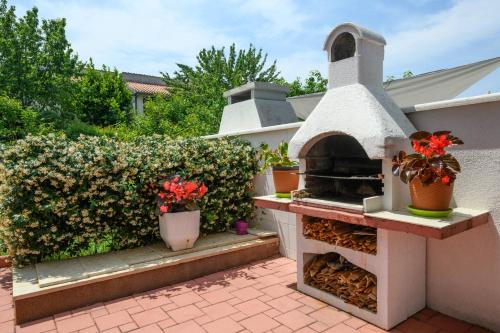 a outdoor pizza oven on a patio with plants at Apartments SoMi in Poreč