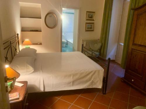 a bedroom with a white bed and a bathroom at Casa Urbano in Taormina