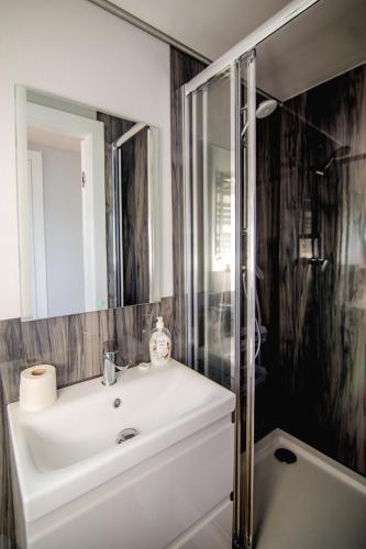 a bathroom with a white sink and a shower at Houseboat- dom na wodzie z sauną i możliwością pływania in Iława