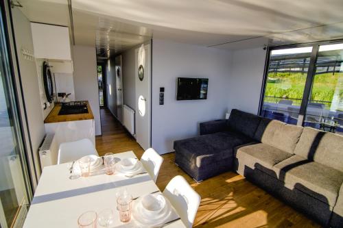 un soggiorno con un divano e un tavolo di Houseboat- dom na wodzie z sauną i możliwością pływania a Iława