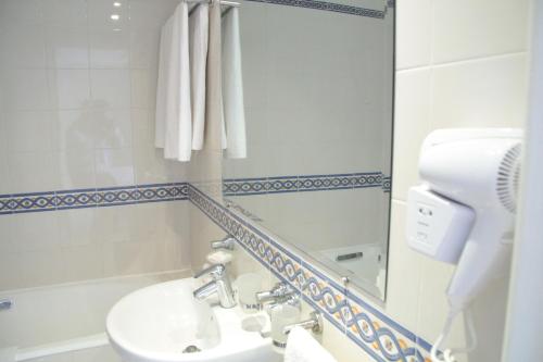 ein Bad mit einem Waschbecken und einem Spiegel in der Unterkunft El Kantaoui Center in Sousse