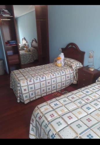 a bedroom with two beds and a mirror at Apartamento cerca de playas in Soto del Barco