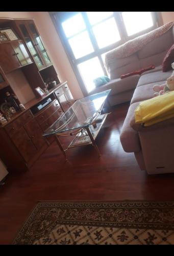 - un salon avec un canapé et une table basse en verre dans l'établissement Apartamento cerca de playas, à Soto del Barco