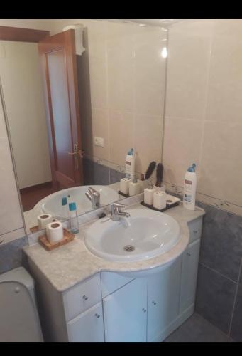 La salle de bains est pourvue d'un lavabo et d'un miroir. dans l'établissement Apartamento cerca de playas, à Soto del Barco
