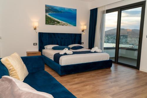 a hotel room with two beds and a couch at Hilltop Heaven Hotel in Sarandë
