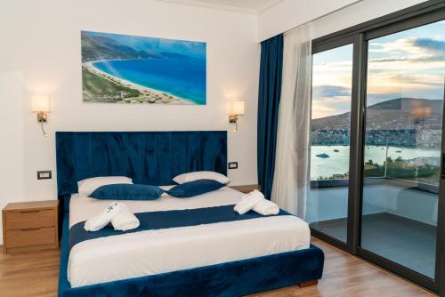 a bedroom with a bed with a view of the ocean at Hilltop Heaven Hotel in Sarandë
