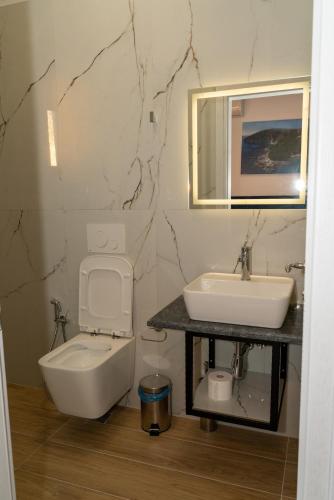 a bathroom with a sink and a toilet at Hilltop Heaven Hotel in Sarandë