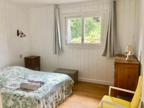 une chambre avec un lit et une fenêtre dans l'établissement Maison Nature Bretagne 3 chambres Plain-Pied, à Langonnet