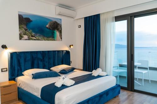 a bedroom with a bed with a view of the ocean at Hilltop Heaven Hotel in Sarandë