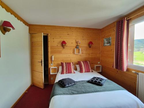 A bed or beds in a room at Logis Hotel Les Playes