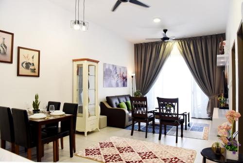 a living room with a table and chairs and a couch at Lovely Mines Astetica Lake View Seri Kembangan 2BR in Seri Kembangan