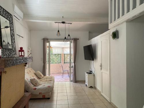 a living room with a couch and a tv at MINI VILLA BORD DE MER in San-Nicolao