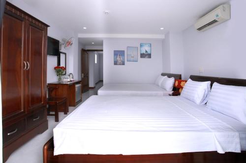 Łóżko lub łóżka w pokoju w obiekcie Nhatrang Cozy Hotel