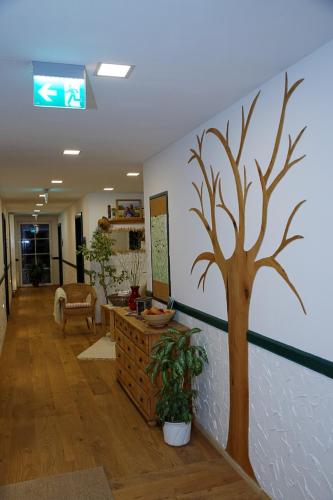 a hallway with a tree painted on the wall at Krumbacherhof in Krumbach Markt
