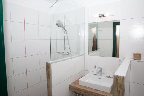 a white bathroom with a sink and a mirror at Krumbacherhof in Krumbach Markt