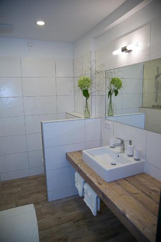 a white bathroom with a sink and a mirror at Krumbacherhof in Krumbach Markt