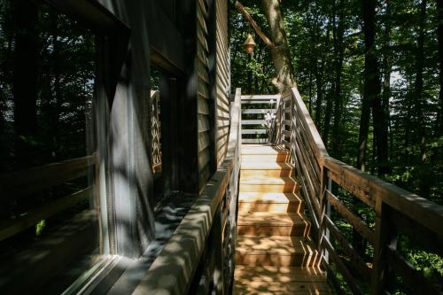 uma escada de madeira que leva a uma casa com árvores em Baumhaus Silent 