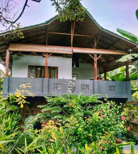a house with a bench in front of it at Sumatra Orangutan Discovery Villa in Bukit Lawang