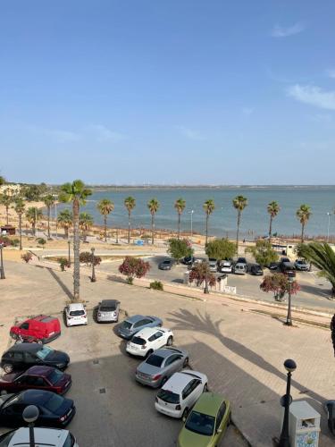 a bunch of cars parked in a parking lot near the beach at Piso playa Maktub in Puerto Real