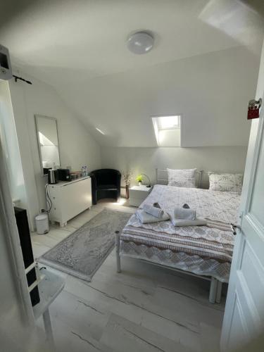 a white bedroom with a large bed and a mirror at La Maison Bleue à 2 pas du Lac du Neuchâtel in Hauterive