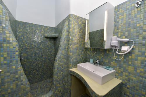 a bathroom with a sink and a mirror at TINOS AQUA PALAZZO in Tinos Town