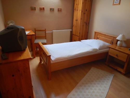 a bedroom with a bed with a tv and a desk at Penzión Réva in Turna nad Bodvou