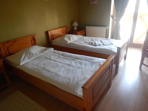 two twin beds in a room with a window at Penzión Réva in Turna nad Bodvou